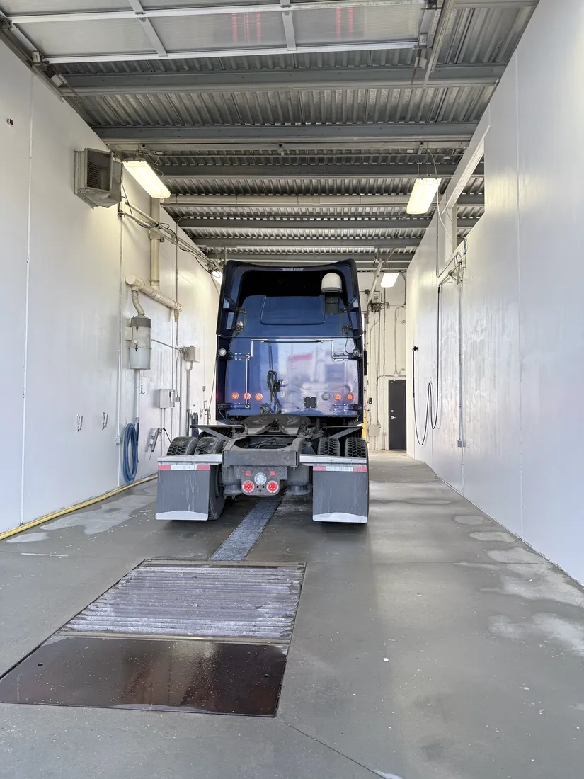 A semi tractor parked in one of the RV and truck bays, with room to walk all the way around it