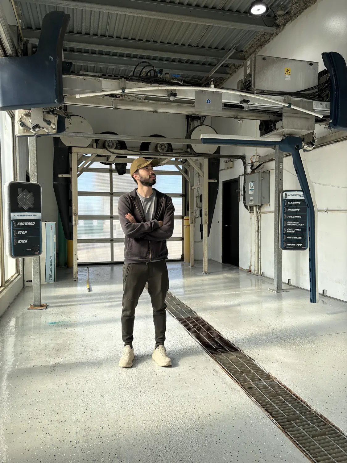 Inside the touchless automatic bay: the LaserWash gantry overhead, with the Forward, Stop, Back sign on one side and the wash-stage sign on the other